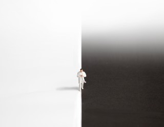 Eine Figur steht vor einem schwarz-weißen Hintergrund.